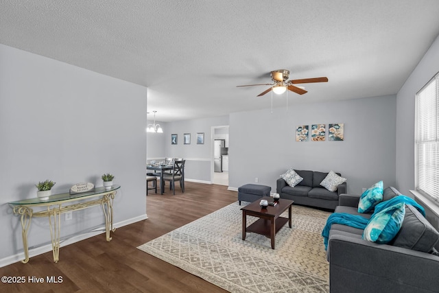 living room with hardwood / wood-style flooring, ceiling fan with notable chandelier, and a textured ceiling