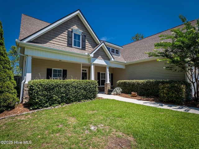 214 Admiral Ct, Sneads Ferry, NC 28460 - craftsman-style home with roof with shingles, a front yard, and covered porch