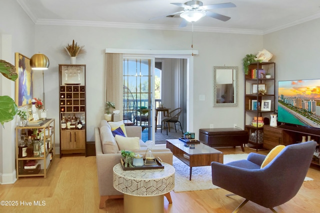 living area with crown molding, ceiling fan, and light wood-type flooring