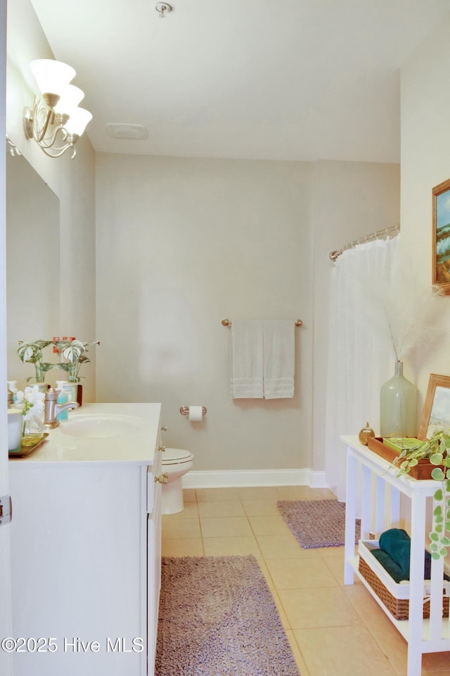 bathroom featuring tile patterned flooring, vanity, a notable chandelier, and toilet