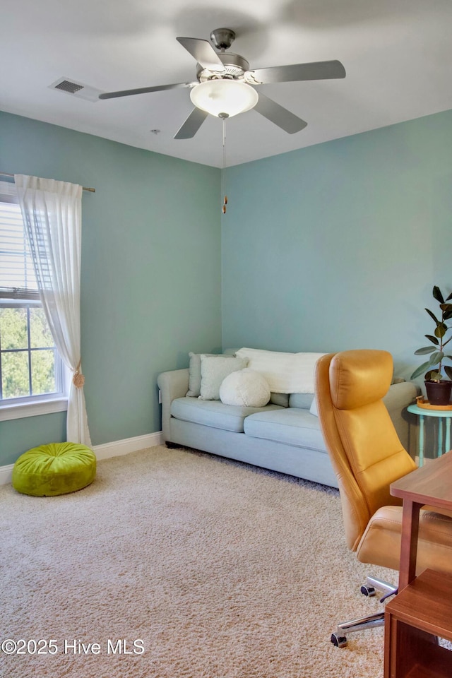 carpeted living room with ceiling fan