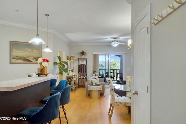 interior space with ceiling fan, ornamental molding, and light hardwood / wood-style floors