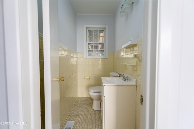 bathroom with vanity, toilet, tile patterned flooring, and tile walls