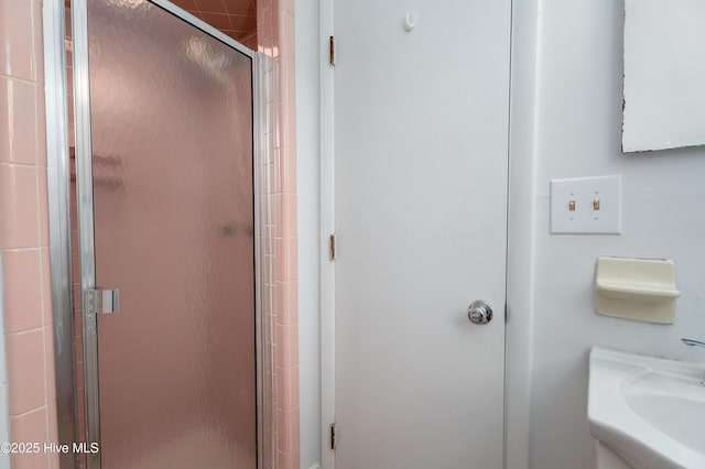 bathroom featuring an enclosed shower and sink