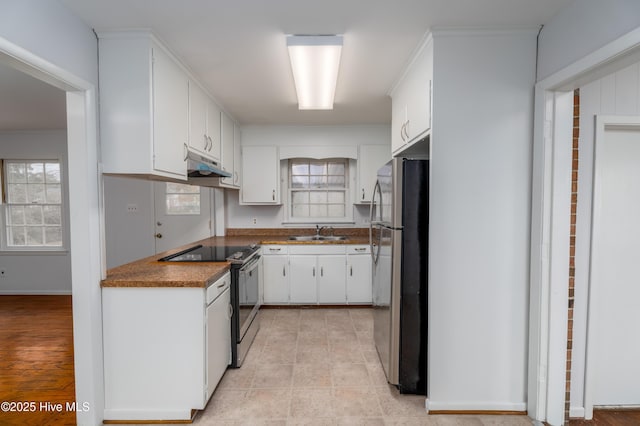 kitchen with stainless steel appliances, white cabinetry, sink, and ornamental molding