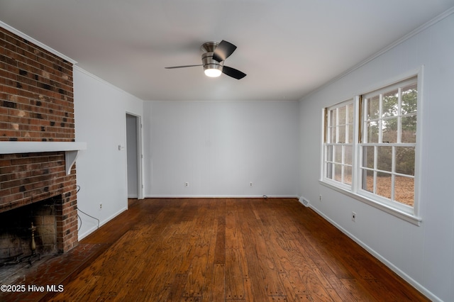 unfurnished living room featuring dark wood-type flooring, ceiling fan, ornamental molding, and a brick fireplace