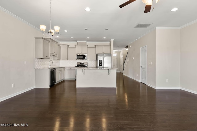 kitchen with gray cabinets, stainless steel appliances, a kitchen island, dark hardwood / wood-style flooring, and decorative backsplash