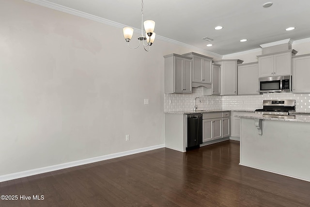 kitchen with pendant lighting, gray cabinetry, backsplash, stainless steel appliances, and light stone counters