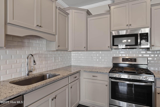 kitchen featuring light stone countertops, appliances with stainless steel finishes, sink, and backsplash