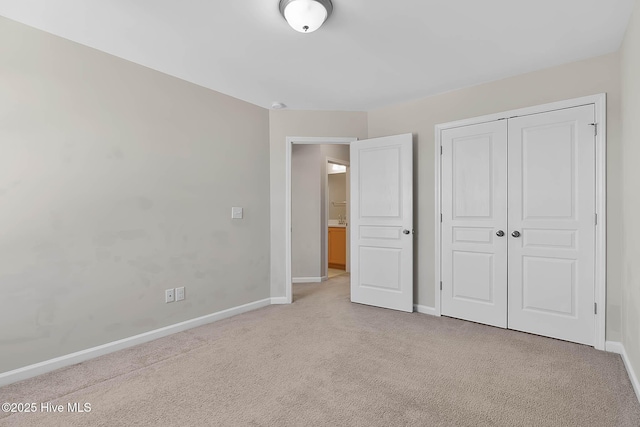 unfurnished bedroom with a closet and light carpet