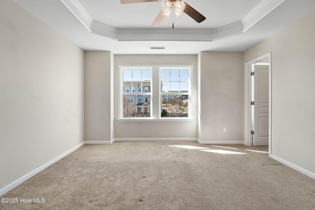 carpeted spare room featuring crown molding, ceiling fan, and a raised ceiling