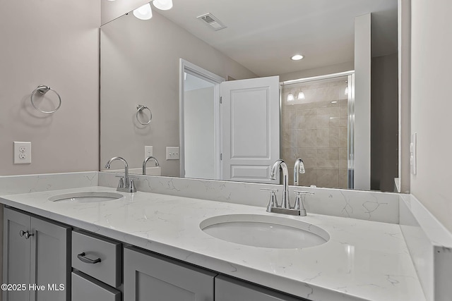 bathroom featuring a shower with door and vanity