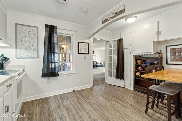 dining space featuring ornamental molding and light wood-type flooring