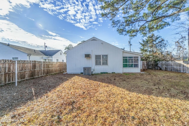 rear view of house with a yard and cooling unit