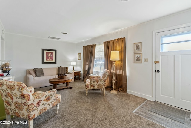 living room with crown molding and carpet