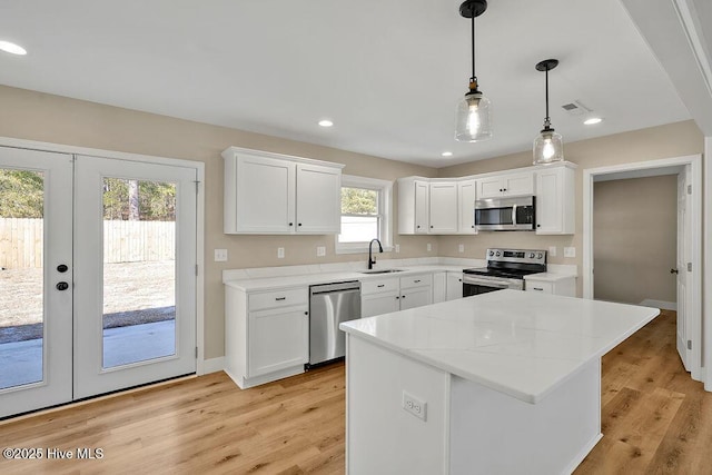 kitchen featuring white cabinetry, appliances with stainless steel finishes, sink, and pendant lighting