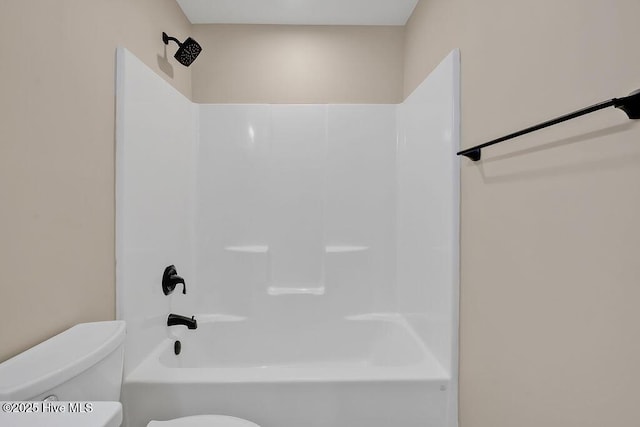 bathroom featuring tub / shower combination and toilet