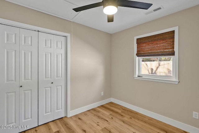 unfurnished bedroom featuring ceiling fan, light wood-type flooring, and a closet