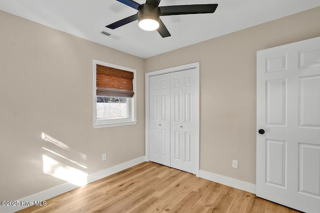 unfurnished bedroom with ceiling fan, light wood-type flooring, and a closet