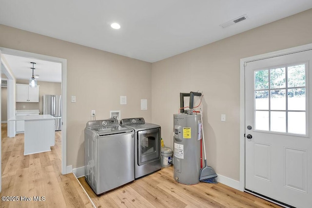 laundry area featuring washer and dryer, electric water heater, and light hardwood / wood-style floors