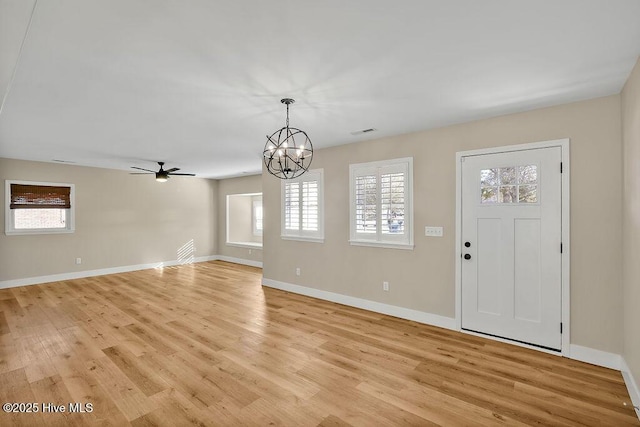 foyer entrance featuring ceiling fan with notable chandelier and light hardwood / wood-style floors