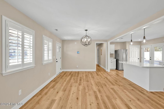 interior space featuring a chandelier, light hardwood / wood-style floors, and french doors