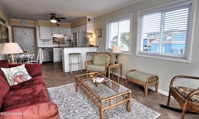 living room with crown molding, ceiling fan, tile patterned floors, and sink