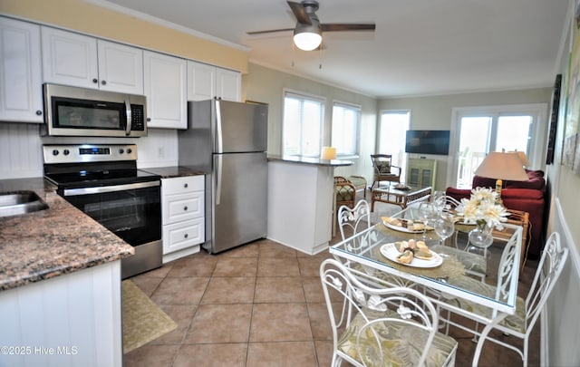 kitchen featuring white cabinetry, light tile patterned floors, a wealth of natural light, and appliances with stainless steel finishes