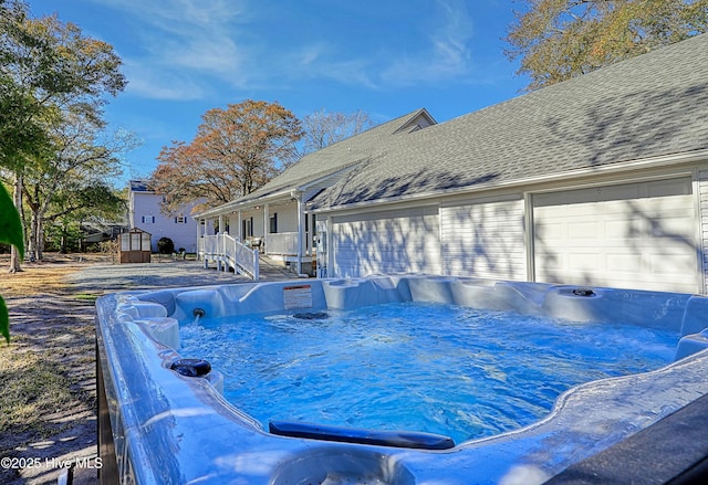 view of pool with an outbuilding and a storage shed