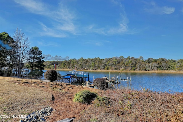 view of dock with a water view and a wooded view