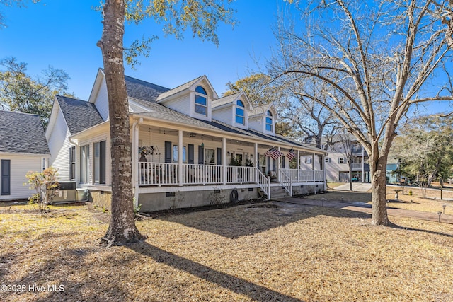 new england style home featuring covered porch, roof with shingles, and crawl space