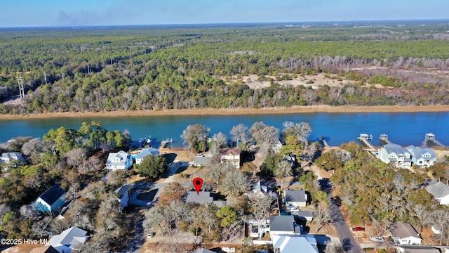 birds eye view of property with a view of trees and a water view