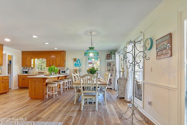 dining space with recessed lighting, light wood-type flooring, and baseboards