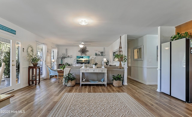 living area with wood finished floors and a ceiling fan