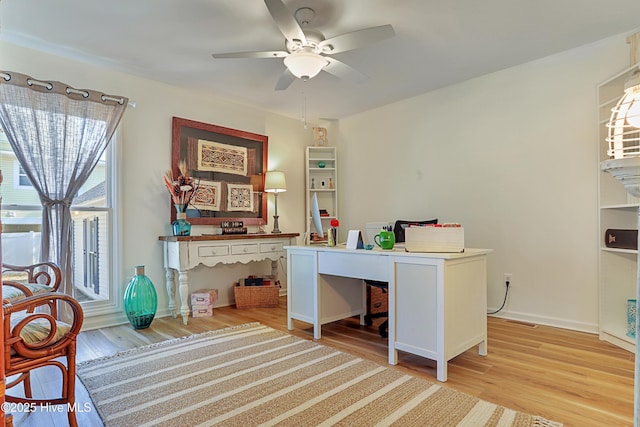 office area featuring light wood finished floors, a ceiling fan, and baseboards