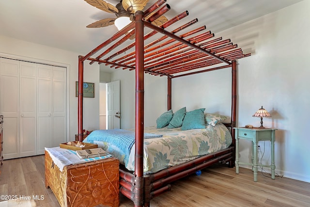 bedroom featuring a closet, baseboards, light wood-type flooring, and a ceiling fan