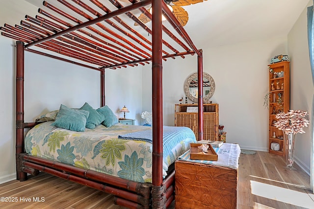 bedroom featuring baseboards and wood finished floors