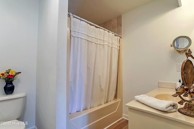 bathroom featuring shower / bath combo with shower curtain, toilet, and vanity