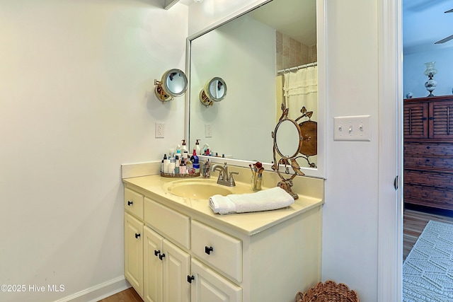 full bathroom with baseboards, wood finished floors, and vanity