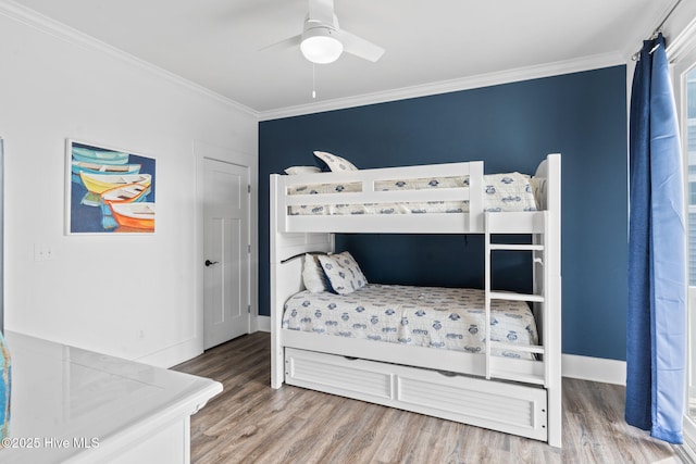 bedroom featuring hardwood / wood-style floors, crown molding, and ceiling fan