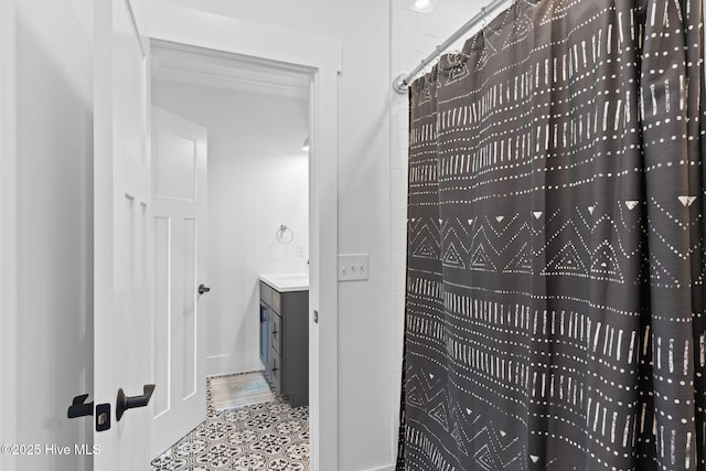 bathroom with vanity, tile patterned floors, ornamental molding, and walk in shower