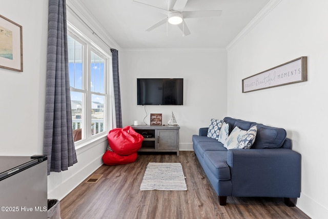 living room featuring ornamental molding, dark wood-type flooring, and ceiling fan