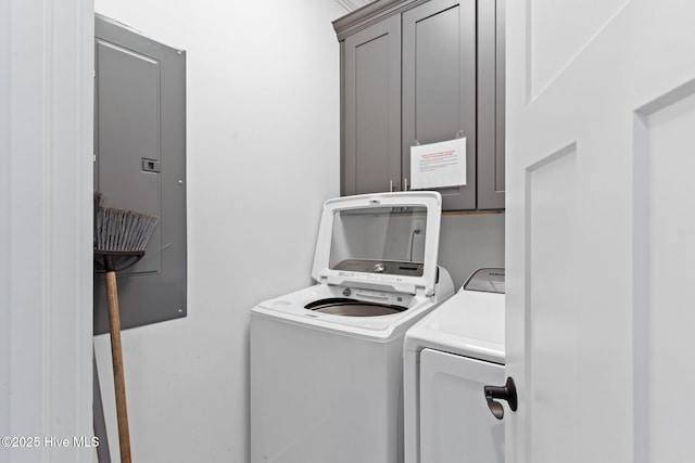 laundry room with washer and dryer, electric panel, and cabinets