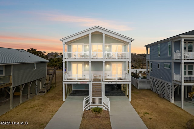 coastal inspired home featuring a carport, a balcony, and a yard