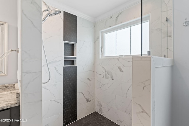 bathroom featuring vanity, ornamental molding, and tiled shower