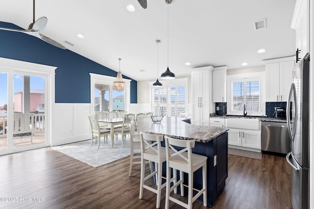 kitchen with sink, white cabinetry, a center island, pendant lighting, and stainless steel appliances