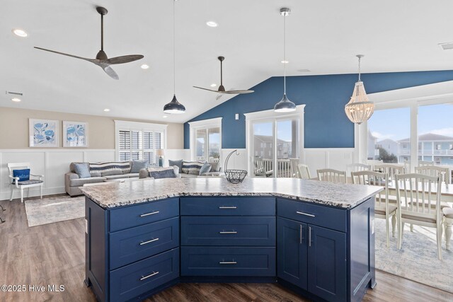 kitchen with blue cabinetry, a healthy amount of sunlight, decorative light fixtures, and a center island