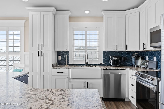 kitchen featuring white cabinetry, a healthy amount of sunlight, stainless steel appliances, and sink