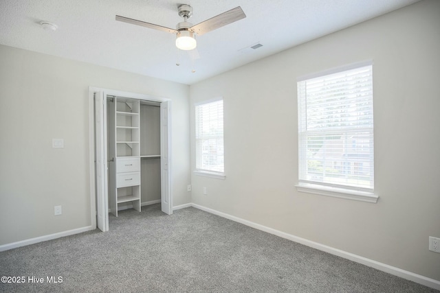 unfurnished bedroom featuring carpet flooring, ceiling fan, and a closet