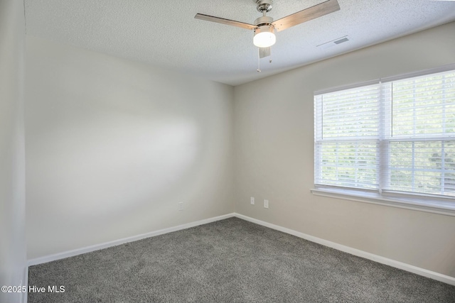 carpeted spare room featuring ceiling fan and a textured ceiling